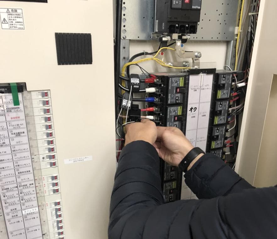 現場の分電盤で導入前後の消費電力を実測している様子