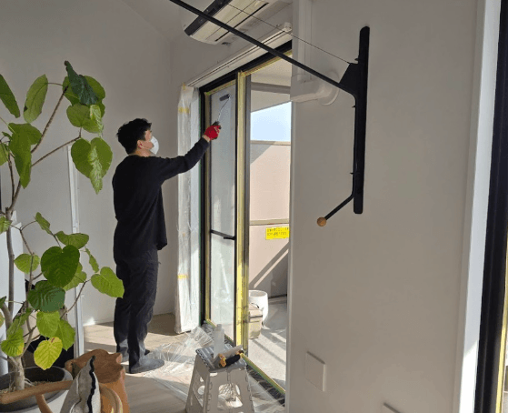 専用ローラーで窓ガラスに節電ガラスコートを塗布する職人